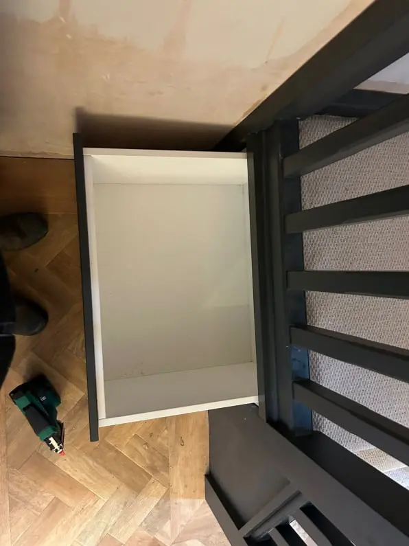 Bespoke hallway under stairs unit with coat hanging rail and overhead shelving