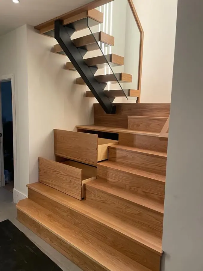 Under stairs cupboard with shelving and pull-out drawers in a modern hallway