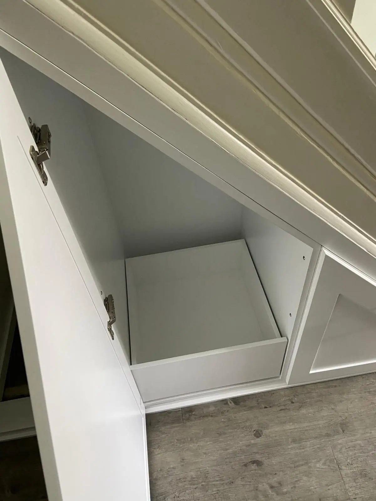 Traditional style under stairs cupboards with panelled doors and chrome handles