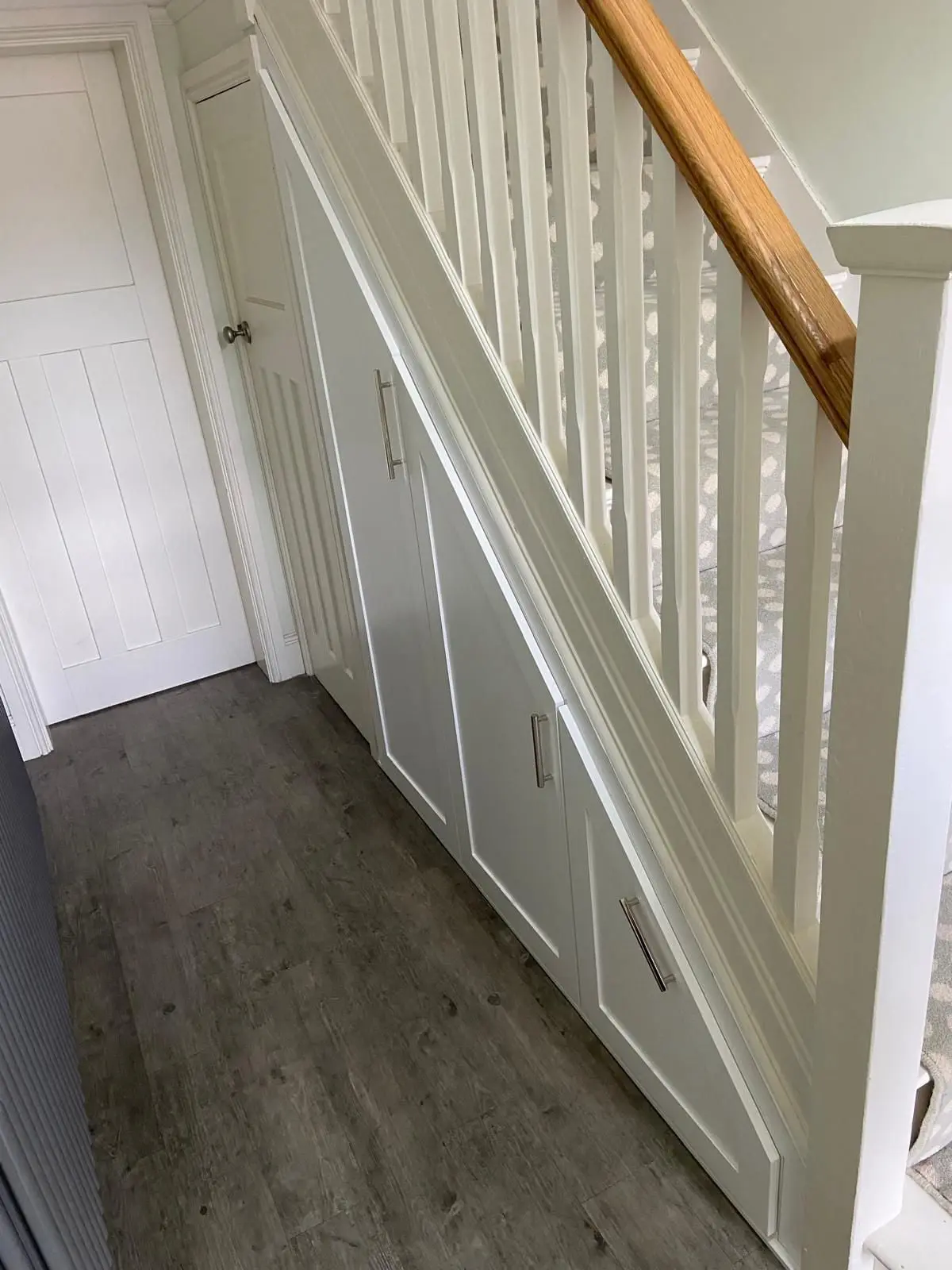 Modern handle-less under stairs storage with push-to-open doors in Trafford
